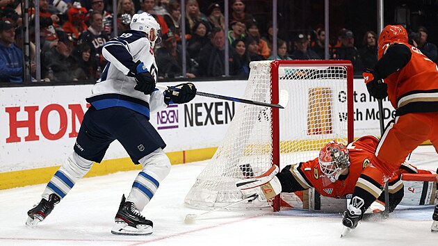 Luk� Dost�l br�n� branku Anaheimu p�ed �tokem Jonathana Toewse z Winnipegu.
