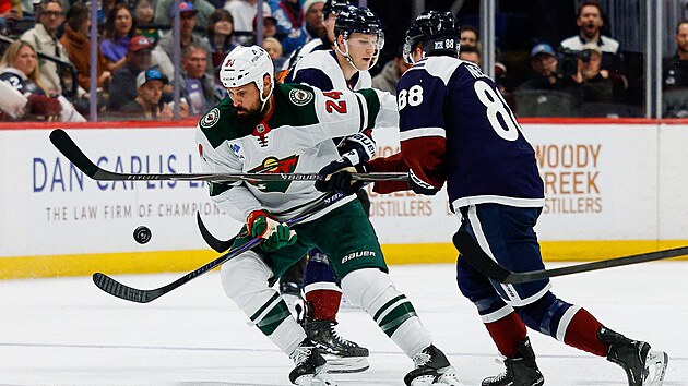 Minnesotsk� obr�nce Zach Bogosian si sna�� zpracovat puk p�ed Martinem Ne�asem z Colorada.