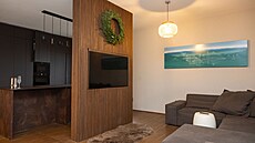 Obývací prostor a kuchy� od sebe odd�luje st�na s ob�í televizí.