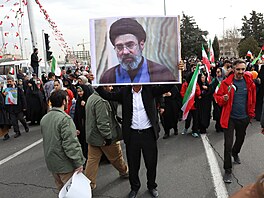 Íránec b�hem oslav výro�í Islámské revoluce nese portrét Mod�taby Chameneího,...