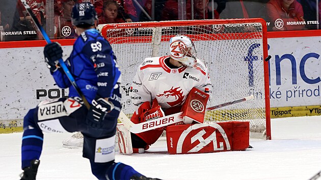 T�ineck� brank�� Marek Mazanec sleduje po st�ele Petra Hausera puk let�c� do lev� ty�e.