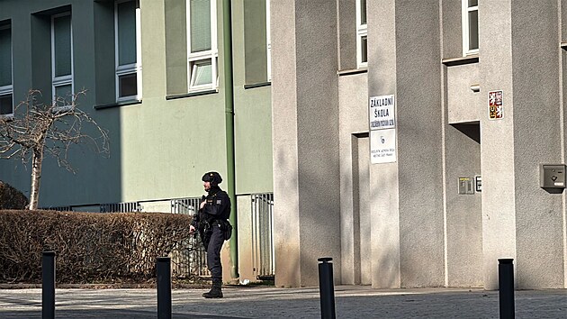 Policista hl�dkuj�c� p�ed z�kladn� �kolou Marj�nka z d�vodu nahl�en� bomby. (5. b�ezna 2026)