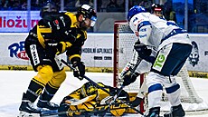 Litvínovský branká� Pavel �ajan si kryje puk, brání ho Adam Polá�ek, dotírá...