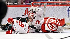 T�inecký branká� Marek Mazanec na led� po souboji svého spoluhrá�e Patrika...