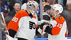Dan Vlada� z Philadelphia Flyers p�ijímá gratulace od spoluhrá�e Garneta...