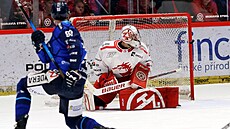 T�inecký branká� Marek Mazanec sleduje po st�ele Petra Hausera puk letící do...