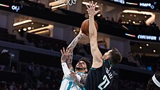 LaMelo Ball ze Charlotte se sna�í dostat mí� do ko�e Portlandu p�es obranu Víta...