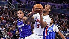 Ron Holland II. (5) z Detroitu jde i p�es faul Desmonda Banea (3) do ko�e...