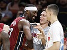 Bam Adebayo p�ijímá gratulace od spoluhrá�� Pelleho Larssona a Tylera Herroa k...