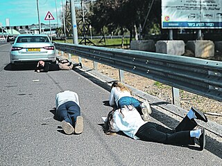 Co nejblí�e k zemi. Izraelci le�í na silnici p�i raketovém útoku. Sni�uje se...