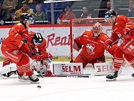 Olomoucký obránce Adam Rutar p�ed svou brankou tla�í k ledu t�ineckého úto�níka...