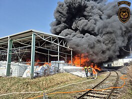 V pr�myslovém areálu v Otrokovicích ho�í materiál pod zast�e�eným prostorem....