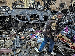 Mu� prochází kolem trosek na míst�, kde v noci prob�hly izraelské letecké údery...