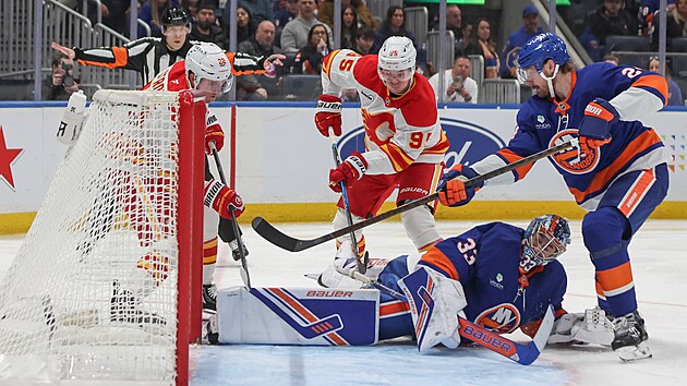 David Rittich v br�n� Islanders zasahuje proti akci Ryana Stromea (22) a Victora Olofssona z Calgary.