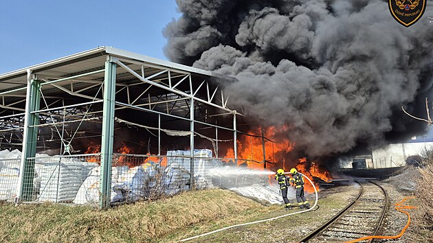 V pr�myslov�m are�lu v Otrokovic�ch ho�� materi�l pod zast�e�en�m prostorem. (10. b�ezna 2026)