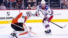 Alexis Lafreniere z NY Rangers p�ekonává Daniela Vlada�e v brance Philadelphie.