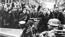 Zden�k Kárný (s aktovkou mezi dv�ma strá�níky) spolu s dal�ími rozzu�enými...