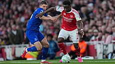 K�ídelník Bukayo Saka z Arsenalu obchází s mí�em Vitalije Mykolenka z Evertonu.
