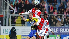 Slávistický wingbek Samuel Isife hlavi�kuje v souboji s Tomá�em Poznarem ze...