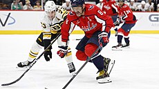 Washingtonský úto�ník Alex Ove�kin s pukem p�ed Charliem McAvoyem z Bostonu