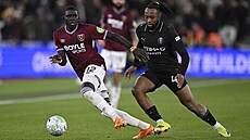 Obránce Malick Diouf z West Hamu s mí�em p�ed Antoinem Semenyem z Manchesteru...