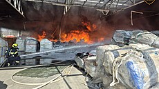 V pr�myslovém areálu v Otrokovicích ho�í materiál pod zast�e�eným prostorem....