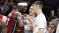 Bam Adebayo p�ijímá gratulace od spoluhrá�� Pelleho Larssona a Tylera Herroa k...