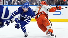 Auston Matthews z Toronto Maple Leafs dostává v zápase s Anaheim Ducks úder do...