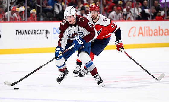 Coloradský obránce Cale Makar s pukem p�ed Tomem Wilsonem z Washingtonu