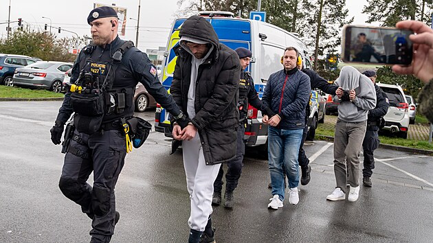 Policie p�ivezla ke zl�nsk�mu okresn�mu soudu na vazebn� zased�n� t�i obvin�n� v kauze korupce ve fotbale, mezi nimi je b�val� funkcion�� FC Zl�nsko a n�kdej�� prvoligov� rozhod�� Pavel B�ma (se sluch�tky na u��ch).