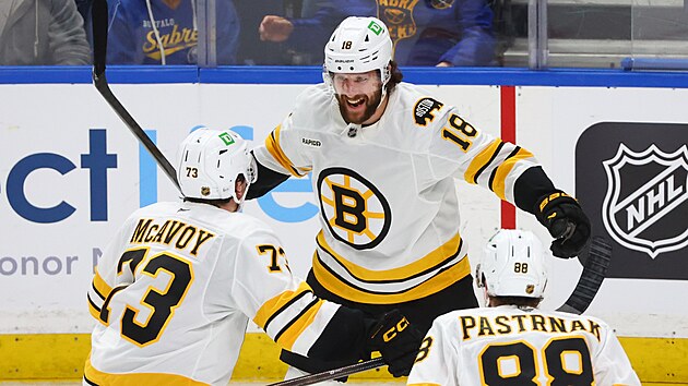 Pavel Zacha (18), Charlie McAvoy (73) a David Pastr��k (88) z Boston Bruins slav� v z�pase s Buffalo Sabres.
