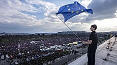 Mladík mává vlajkou na st�e�e budovy na Letenské pláni p�i probíhající...