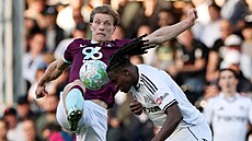 Calvin Bassey z Fulhamu neohro�en� hlavi�kuje p�ed Flemmingem z Burnley.