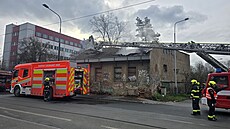 Hasi�i zasahují u po�áru st�echy vybydlené budovy v pra�ské Michli (26. b�ezna...