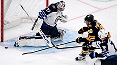 David Pastr�ák z Bostonu (v �erném) operuje p�ed brankou Winnipegu v utkání NHL.