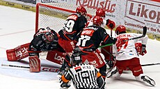 T�ine�tí hokejisté se sna�í dotla�it kotou� za brankovou �áru.
