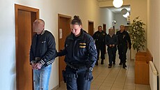 Eskorta p�ivádí sedmat�icetiletého Viktora �. do soudní sín� Okresního soudu...