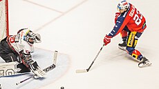 Spar�anský branká� Jakub Ková� zasahuje proti Luká�i Sedlákovi z Pardubic.