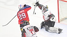 Pardubický Milo� Kelemen te�uje puk p�ed gólmanem Jakubem Ková�em ze Sparty.