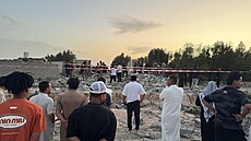 Lidé se shroma��ují na míst�, kde rakety odpálené ze sm�ru Kuvajtu zasáhly d�m...