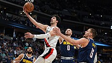 Deni Avdija z Portland Trail Blazers zakon�uje na ko� Denver Nuggets, brání ho...