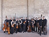 Italský orchestr spolu s dirigentem a koncertním mistrem Alessandrem Tampierim...