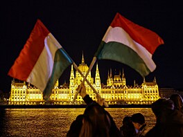 Lidé v Budape�ti dr�í ma�arské vlajky, zatímco �ekají na výsledky parlamentních...