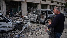 Místní obyvatelé stojí mezi troskami a vozidly zni�enými p�i izraelském...
