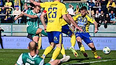 Úto�ník Václav Drchal z Bohemians se sna�í propálit hradbu t�l hrá�� Zlína.