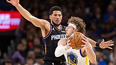 Brandin Podziemski (vpravo) z Golden State se sna�í dostat p�es Devina Bookera...