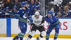 Filip Hronek a Zeev Buium (vpravo) napadají Mathieua Josepha z Los Angeles.