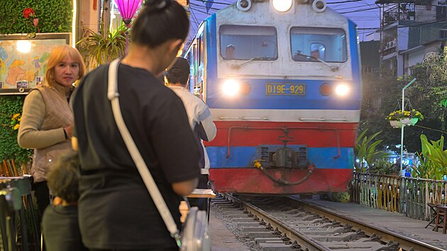 Hanojsk� Train Street l�k� davy, kter� riskuj� �ivot pro fotku s vlakem proj�d�j�c�m jen centimetry od kav�rensk�ch stolk�. I p�es opakovan� z�kazy ��ad� z�st�v� tato �zk� uli�ka symbolem nebezpe�n�ho, ale neodolateln�ho turistick�ho chaosu.