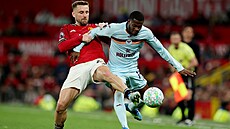 Luke Shaw z Manchesteru United (vlevo) bojuje o mí� s hostujícím Dangem...