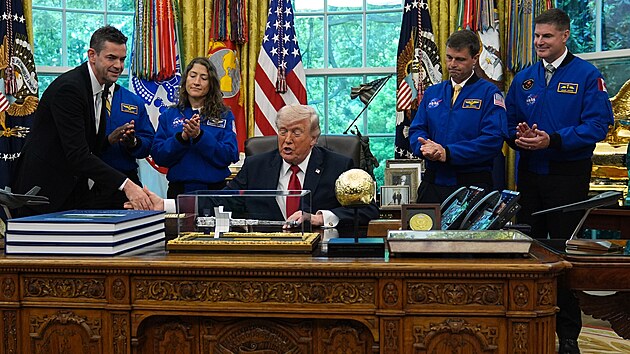 Prezident Donald Trump si pod�v� ruku s �editelem NASA Jaredem Isaacmanem p�i setk�n� s astronauty mise Artemis II NASA Victorem Gloverem, Christinou Kochovou, Reidem Wisemanem a Jeremym Hansenem v Ov�ln� pracovn� B�l�ho domu. (29. dubna 2026)